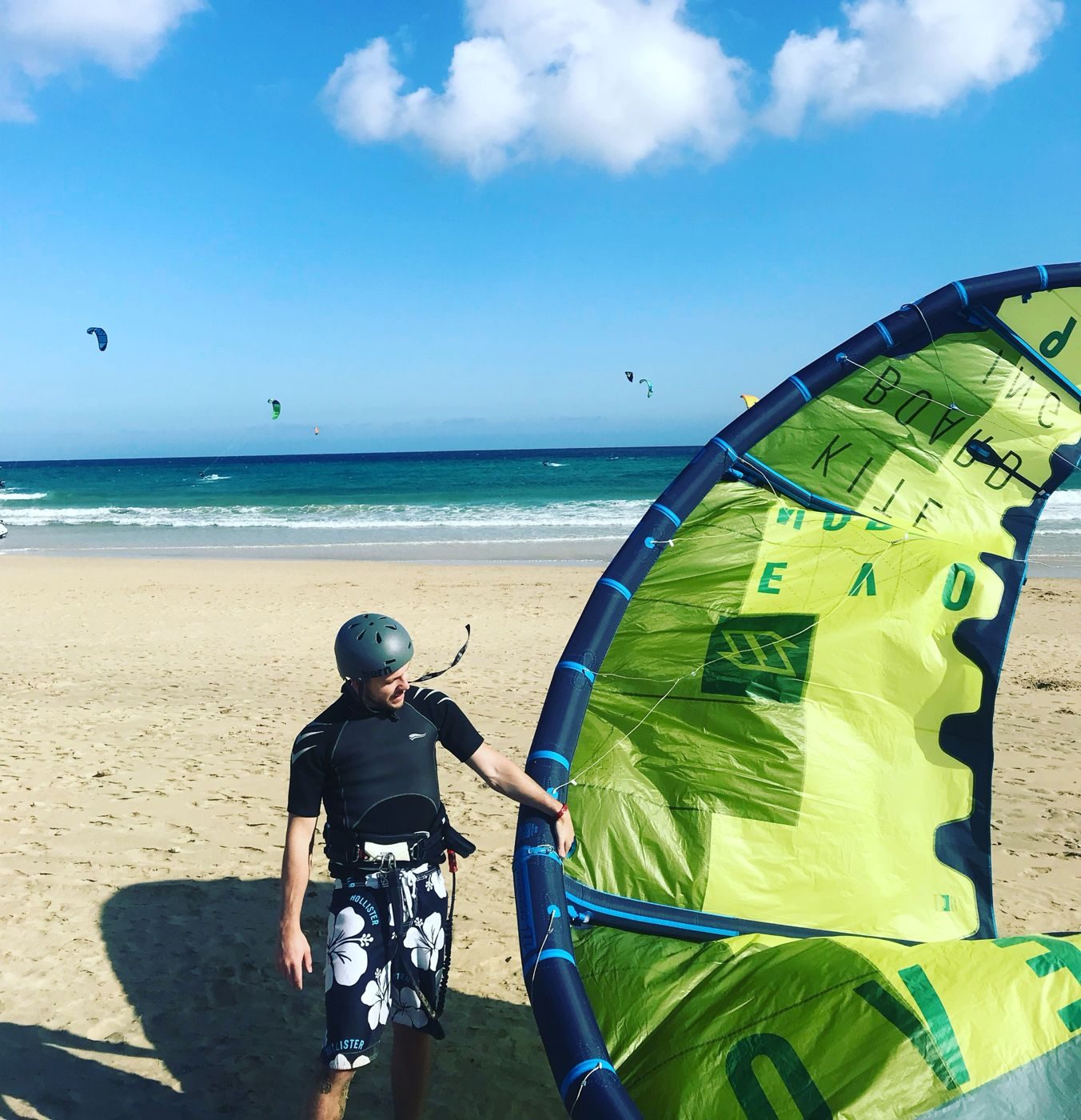 Alex beim Kitesurfen am Strand, neben ihm sein grüner Kite